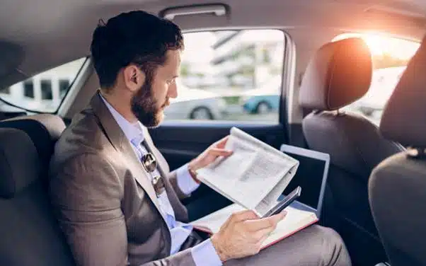 Business traveller reading documents during a private transfer