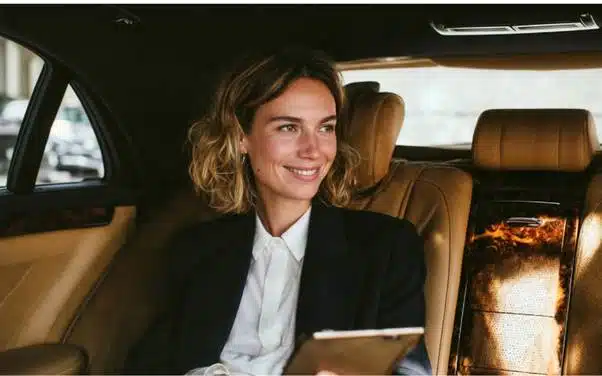 Business traveller using a smartphone in the rear of a car